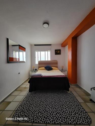 格拉纳达Habitacion muy céntrica.的一间卧室配有一张橙色墙壁的床