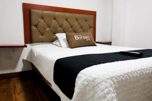 波哥大Hotel Casa botero 106的一张带黑白棉被和枕头的床