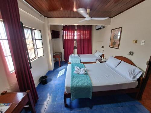 普卡尔帕Hotel Virrey Pucallpa EIRL的一间卧室配有两张床和吊扇