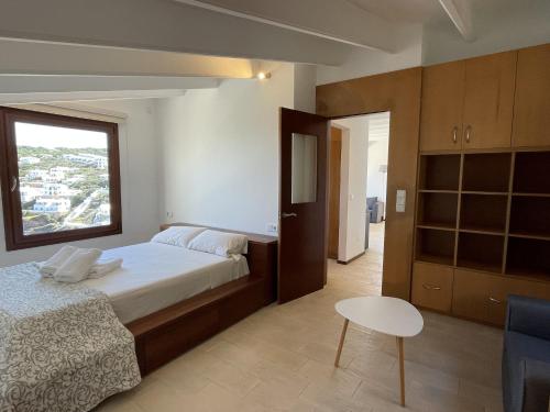 卡拉莫若尔Apto. Ses Ancolles Vistas Mar的一间卧室配有一张床、一张桌子和一个窗户。