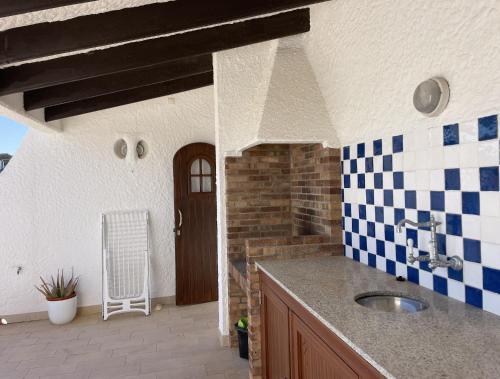 卡拉莫若尔Apto. Ses Ancolles Vistas Mar的厨房配有水槽以及蓝色和白色的瓷砖