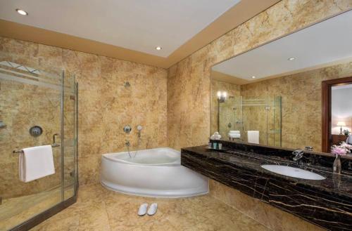 阿布扎比Al Raha Beach Hotel - Superior Room DBL - UAE的一间带浴缸和大镜子的浴室