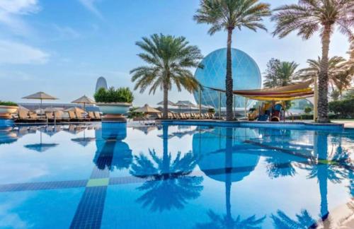 阿布扎比Al Raha Beach Hotel - Superior Room DBL - UAE的棕榈树度假村的游泳池