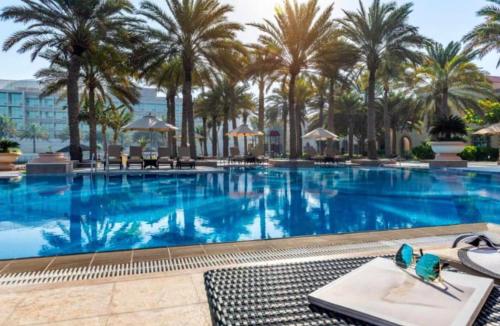 阿布扎比Al Raha Beach Hotel - Superior Room DBL - UAE的度假村内一座种有棕榈树的大型游泳池