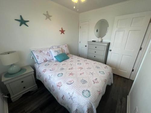 默特尔比奇Sea Shadow 205 Condo的一间小卧室,配有一张床和镜子