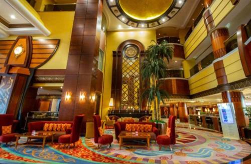 阿布扎比Al Raha Beach Hotel - Gulf View Room SGL - UAE的大厅,在大楼里,配有沙发和时钟