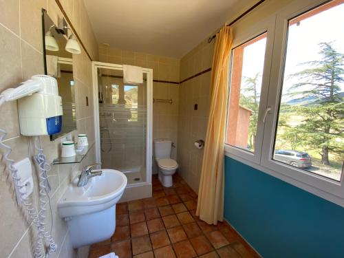屈屈尼昂奥贝尔格拉塔博乐都库乐酒店的一间带水槽和卫生间的浴室以及窗户。