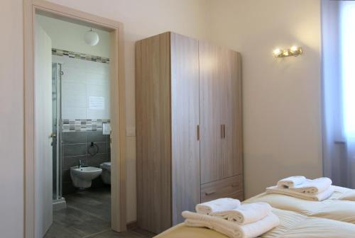 代森扎诺-德尔加达Maison N&M的一间带两张床的卧室和一间带淋浴的浴室
