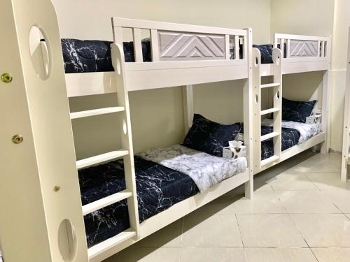 迪拜Ramble stay Hostel Bur Dubai的配有两张白色双层床的客房