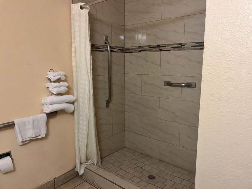 德明Motel 6 Deming, NM的带淋浴的浴室和玻璃门