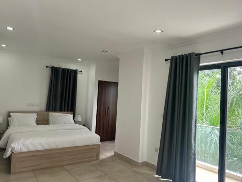 阿克拉Stay Play Away Residences - Luxury 4 bed, Airport Residential, Accra的一间卧室设有一张床和一个大窗户