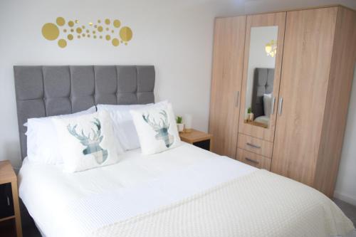 亚姆Orient Oasis Yarm的一间卧室配有一张带白色床单和镜子的床