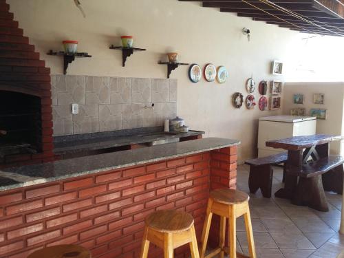 阿尔科巴萨Pousada Pé de Caju的厨房设有2张凳子和1个带砖墙的台面