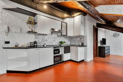 米兰Porta Venezia-Buenos Aires Chalet House in Shopping District Free Wifi Netflix的厨房配有白色橱柜和红色瓷砖地板。