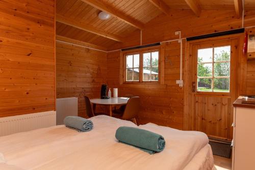 布伦迪欧斯格拉德马尔别墅酒店的木制客房内的一间卧室,配有一张床