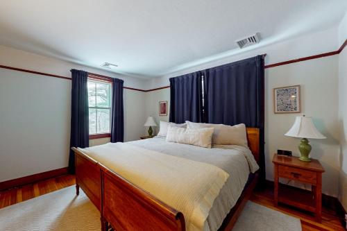 Pocono PinesPine Cone Place的一间卧室配有一张带蓝色窗帘的大床