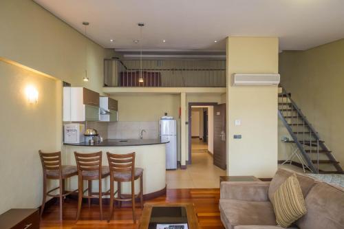 内罗毕Taarifa Suites by Dunhill Serviced Apartments的客厅以及带沙发和桌子的厨房。