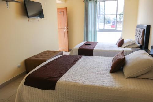 波哥大Hotel Casa Botero 305的酒店客房设有两张床和电视。
