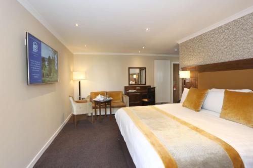 邓迪Invercarse Hotel Dundee, BW Signature Collection的酒店客房设有一张大床和一张书桌。