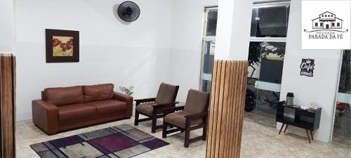 阿帕雷西达Pousada Parada Da Fé的客厅配有沙发和两把椅子