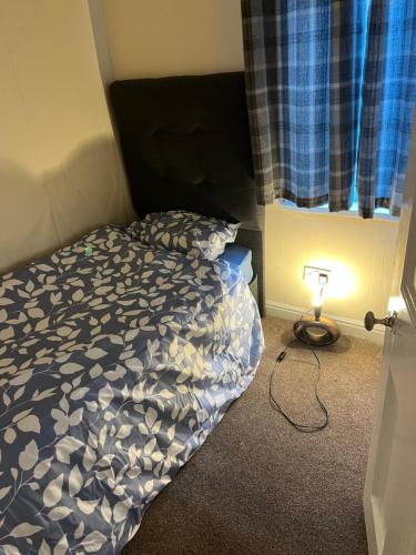 达灵顿Mortiara的一间卧室,配有一张床和一个窗户旁边的灯