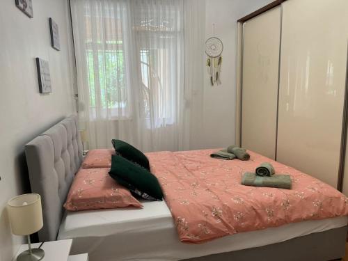 斯普利特Dioklecian Dream Apartment的一间卧室配有带粉色床单和绿色枕头的床。