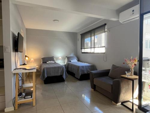 罗萨里奥Premium Apartment Rosario - Joan Miró的一间带两张床和一张沙发的客厅
