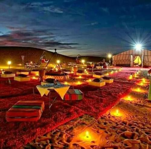 梅尔祖卡Merzouga Luxurious Camp的一群太阳伞在晚上在海滩上