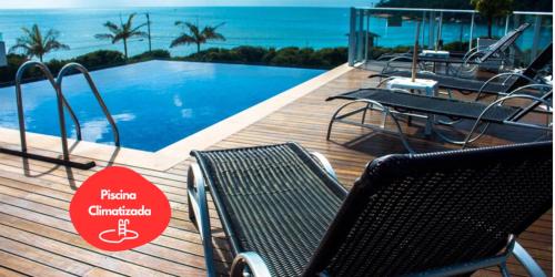 巴拉奈里奥-坎布里乌雷赛尔瓦普莱亚酒店的一个带椅子的甲板和一个海景游泳池