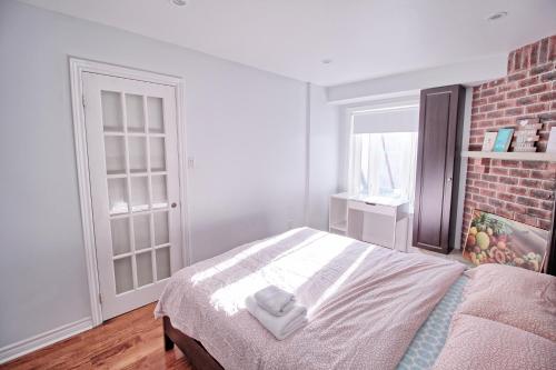沃恩Beautiful room with private powder room的一间卧室设有一张床和砖墙