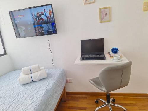利马Habitación baño Compartido La Paz 2的一间卧室,配有一台笔记本电脑,可放置在书桌上