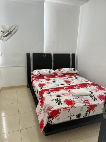 巴耶杜帕尔Lindo Apto con Aire Acond de 3 habitaciones的一间卧室配有一张带红色和白色棉被的床