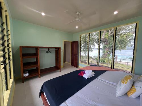 卢甘维尔Lapita Beach Aore Island Vanuatu的一间卧室设有一张大床和大窗户