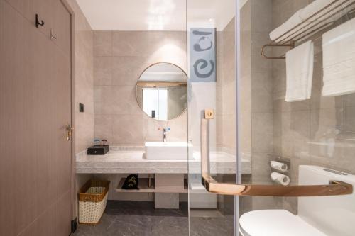 惠州铂顿国际公寓酒店(惠州经济学院店)的一间带水槽、卫生间和镜子的浴室