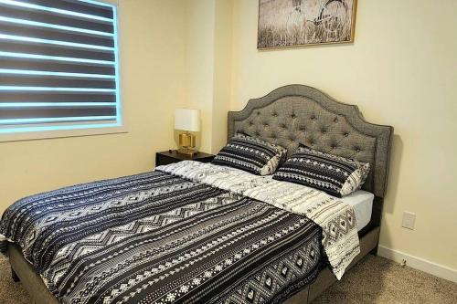 埃德蒙顿Cozy 3 bedroom townhouse in downtown Edmonton的一间卧室配有一张带毯子和枕头的床。
