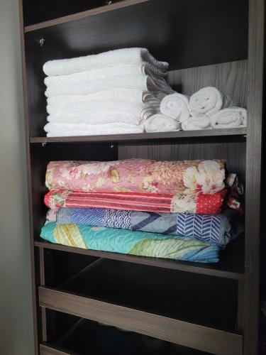 吉巴拉那Casa agradável com área gourmet的装满毛巾和折叠毛巾的架子