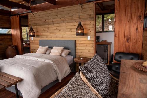马尼萨莱斯Owl's Watch Nature Retreat的一间卧室设有一张床和木墙