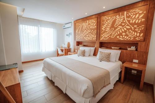阿约拉港Hotel Acacia的一间卧室配有一张大床和木制床头板