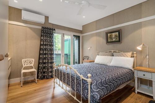 拜伦湾Belongil Laneway的卧室配有床、椅子和窗户。