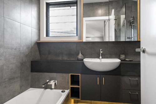 拜伦湾Belongil Laneway的浴室配有盥洗盆和浴缸。