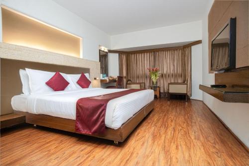 班加罗尔Monarch Brigade Road的酒店客房配有一张带红色枕头的大床
