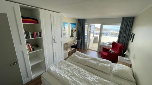 博里霍尔姆Takvåning - Borgholm的一间小卧室,配有一张床和一把红色椅子
