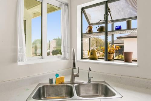 圣巴巴拉Colorful Gold Coast Getaway的厨房水槽上方设有2扇窗户