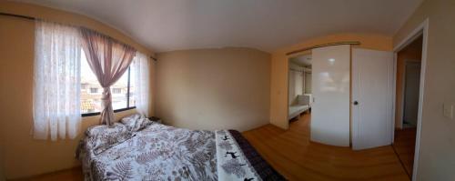 昆卡Casa Anthony的一间卧室设有一张床和一个大窗户
