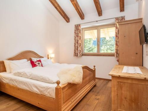 巴特霍夫加施泰因BergChalet Breitenberg的一间卧室设有一张木床和一个窗户。