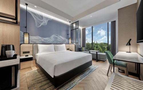 马卡萨Hyatt Place Makassar的配有一张床、一张桌子和一张桌子的酒店客房