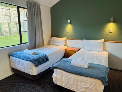 奥克兰奥克伍德庄园汽车旅馆的客房设有两张床和窗户。