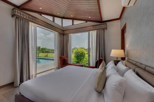 AnjārThe Fern Royal Farm Resort, Anjar的一间卧室设有一张大床和一个大窗户