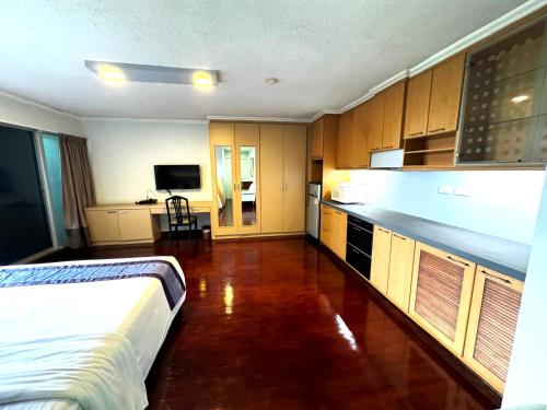 曼谷斯代普沙吞酒店的一间卧室配有一张床,厨房配有橱柜