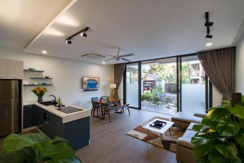 会安Beach Haven Suites Hội An Apartment的厨房以及带沙发和桌子的客厅。